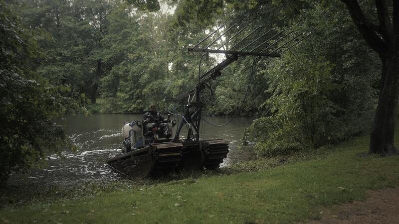 EMGESA Amphibienfahrzeug fährt aus einem See, halb im Wasser, über die Wiese ohne Bodenbeschädigung.