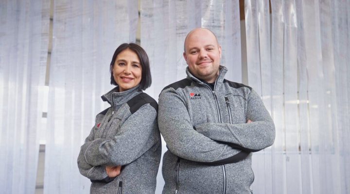 Mitarbeiter der Redur GmbH präsentieren stolz die neue Arbeitskleidung vor dem Kältevorhang zur Energieeinsparung.