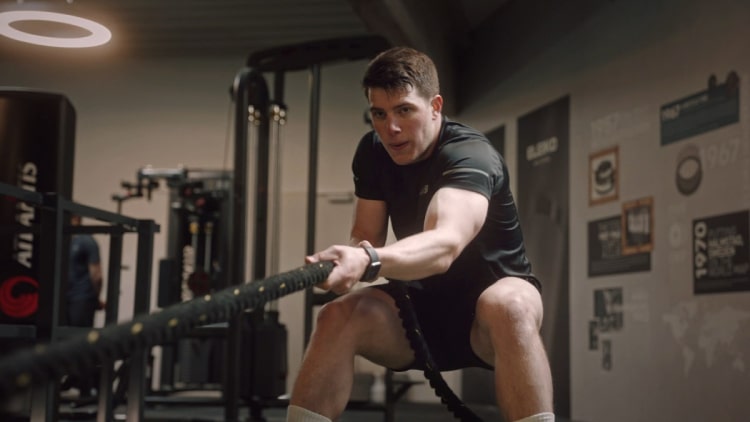 Athlet zieht einen Gewichtsschlitten über einen Grünstreifen im Fitnessstudio für einen Werbefilm der von uns in Hamburg produziert wurde.